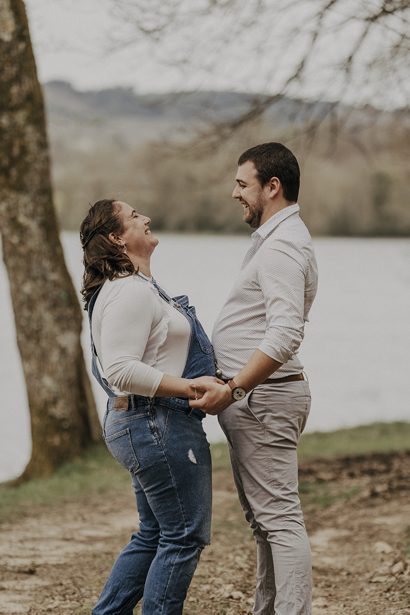 Jeune couple qui rigole ventre contre ventre. La future maman et son ventre rond et le papa avec son ventre gonflé